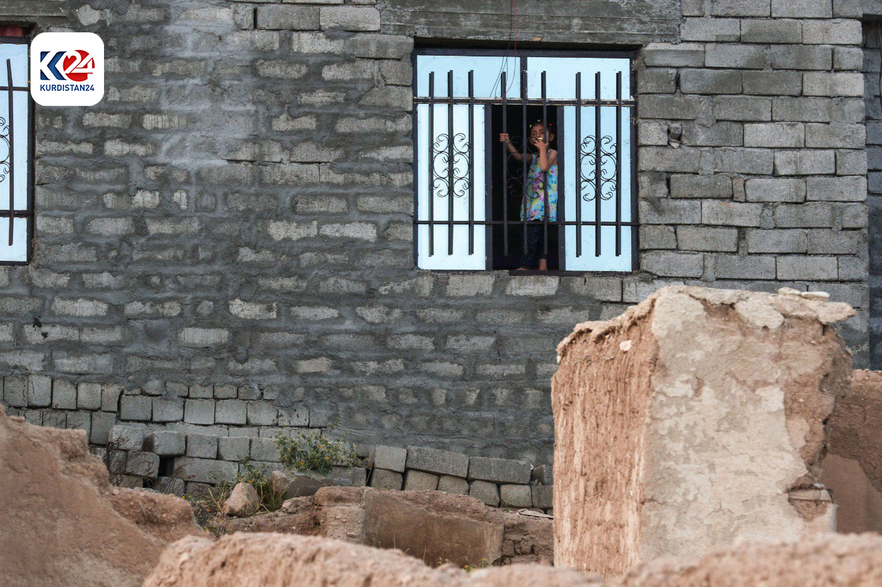 A kid looks outside through a window in Sinjar. (Photo AFP)
